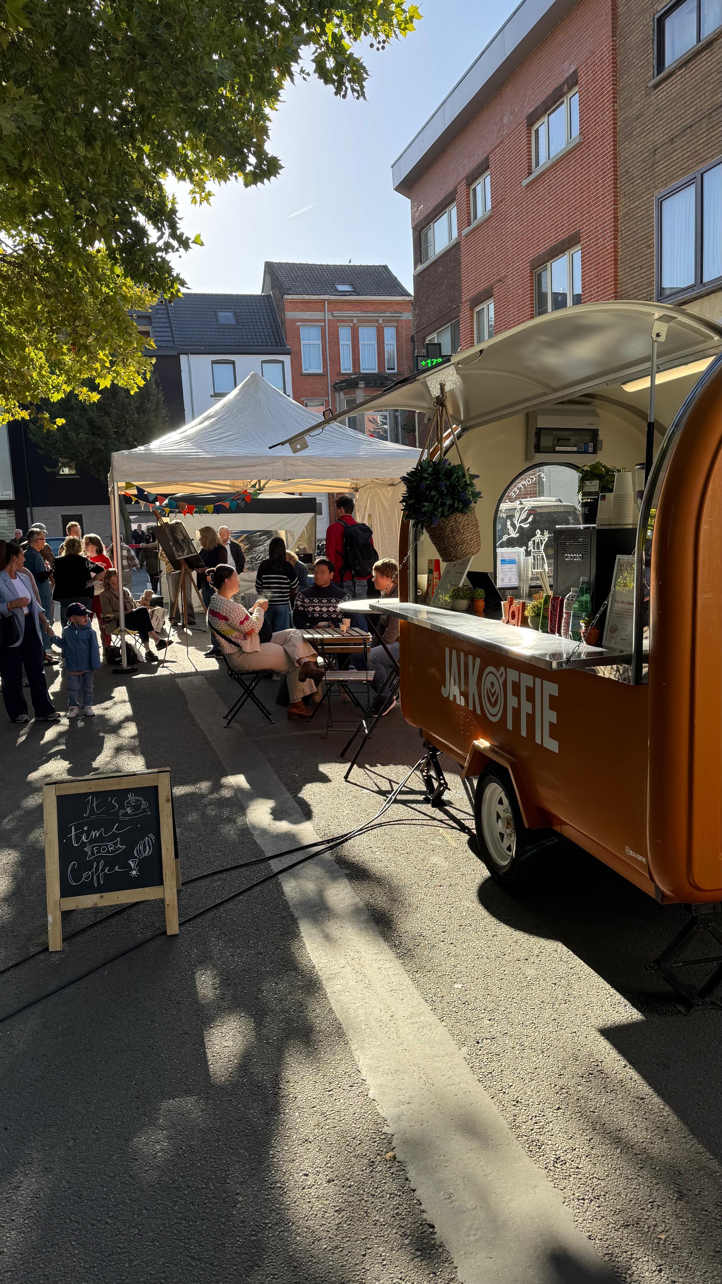 Oranje koffiekar op zondagsmarkt